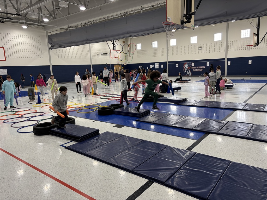 Students in a school gym playing an Olympic themed event.
