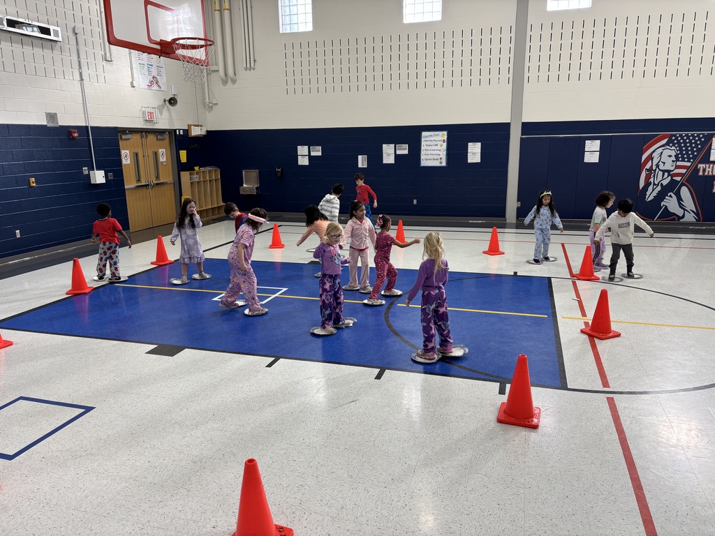 Students in a school gym playing an Olympic themed event.