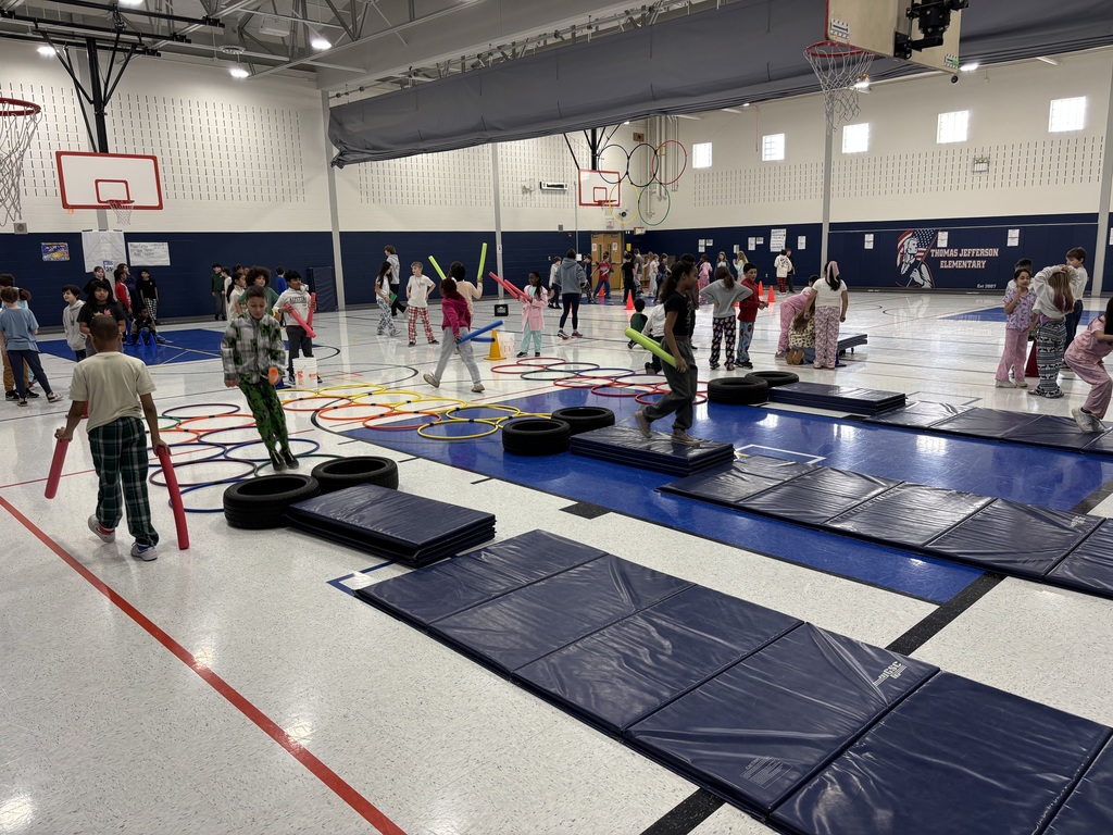 Students in a school gym playing an Olympic themed event.
