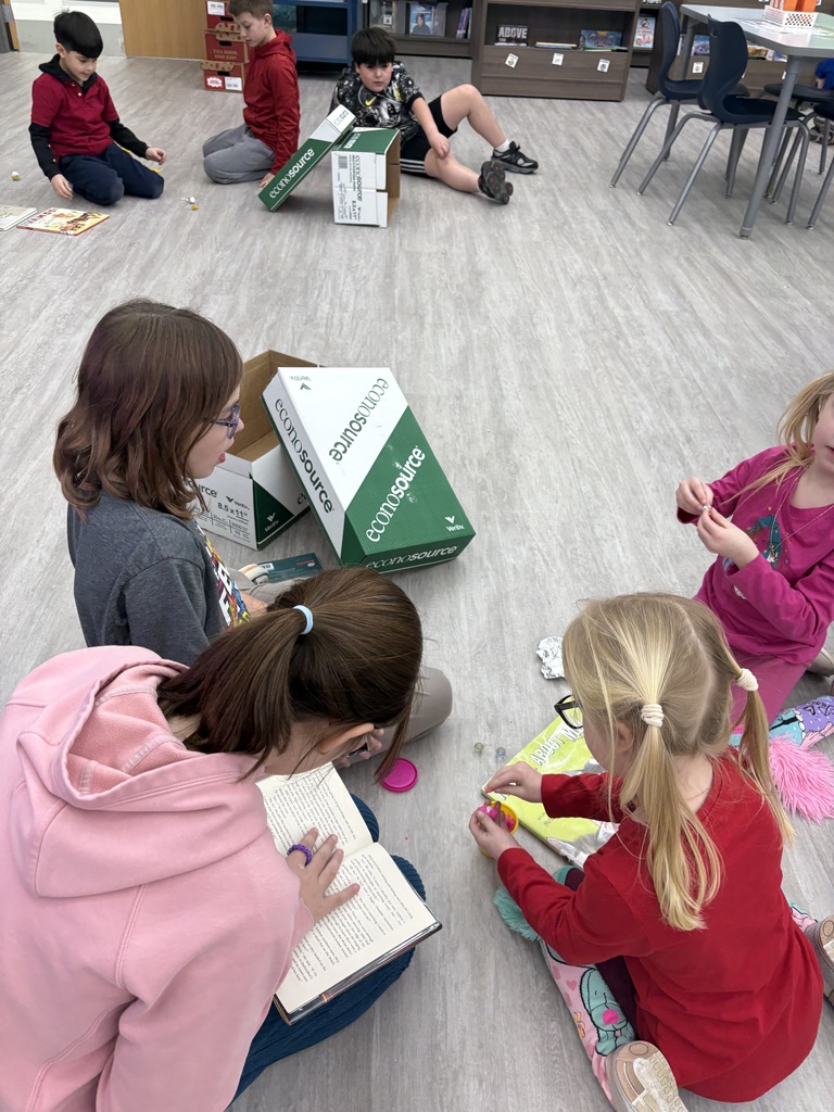 A student wraps a rock in dough to make it round. 