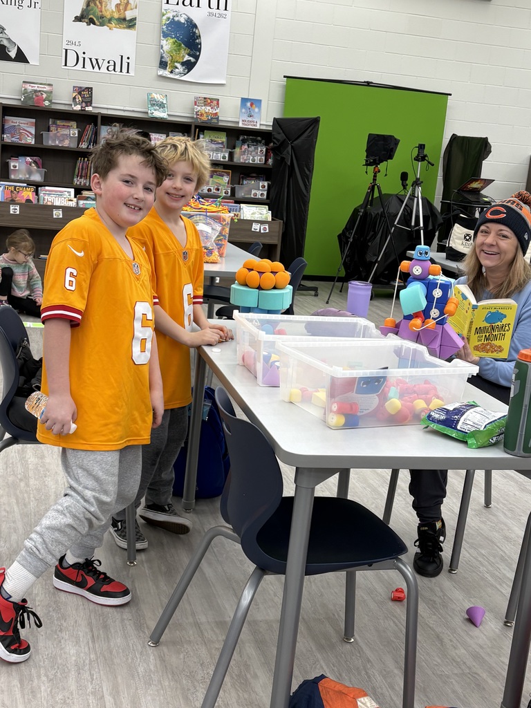 A mom and her two sons in a library using stem building materials