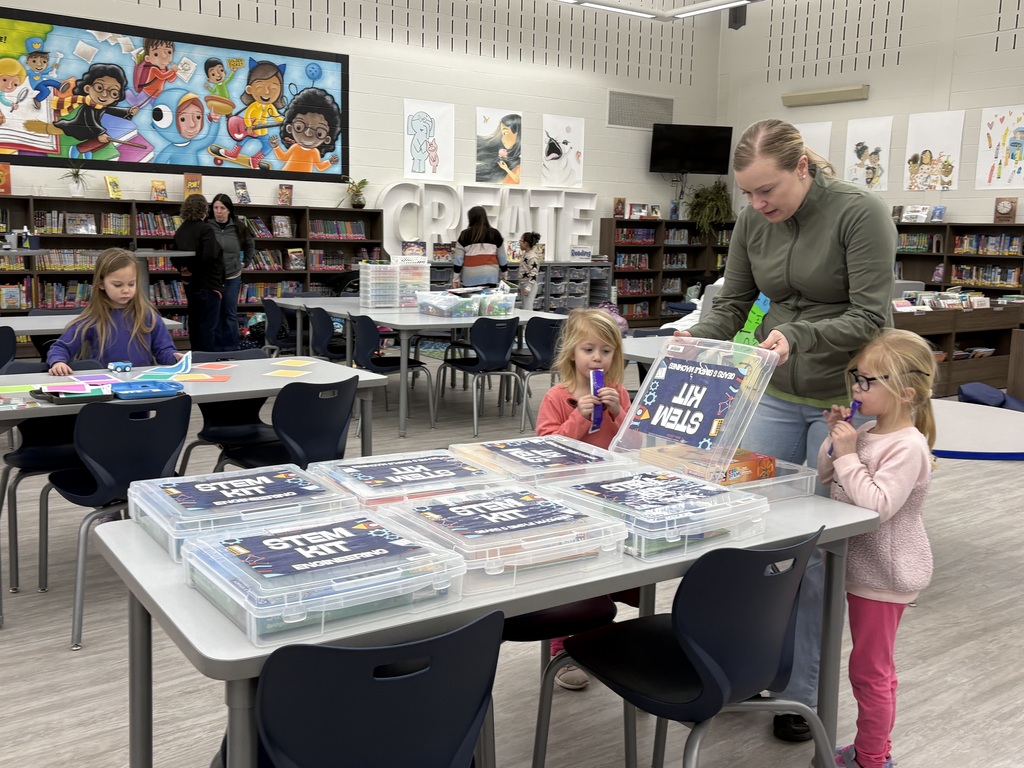 And her two daughters in a library looking at activity kits