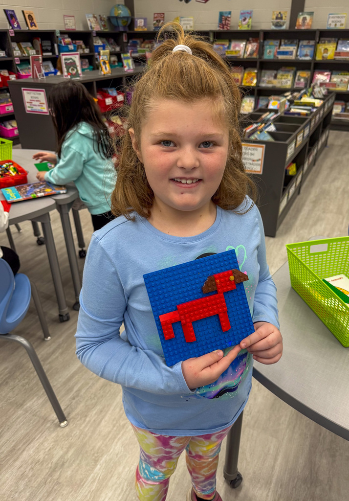 girl holding Lego horse on green background