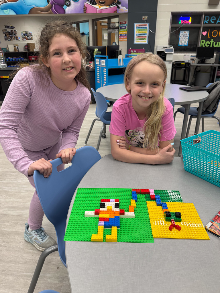 two girls stand with Lego animal creations