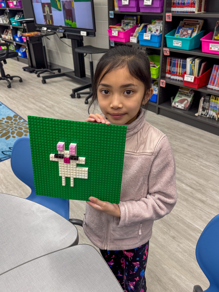 girl holding Lego animal on green background