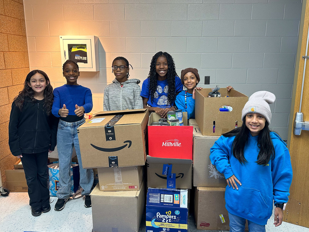 six student stand with boxes filled with food 