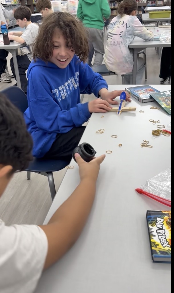 Students building a catapult in the media center. 