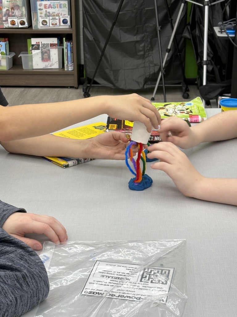 Students building a pipe cleaner rainbow in the media center. 