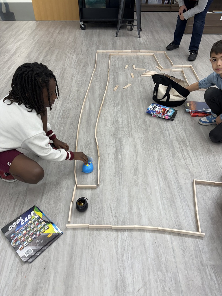 Students building a maze for a coding robot  in the media center. 