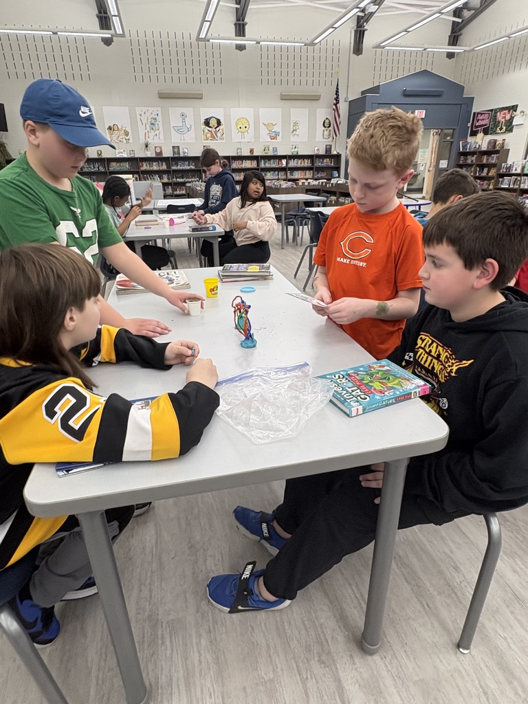 Students building a pipe cleaner rainbow  in the media center. 
