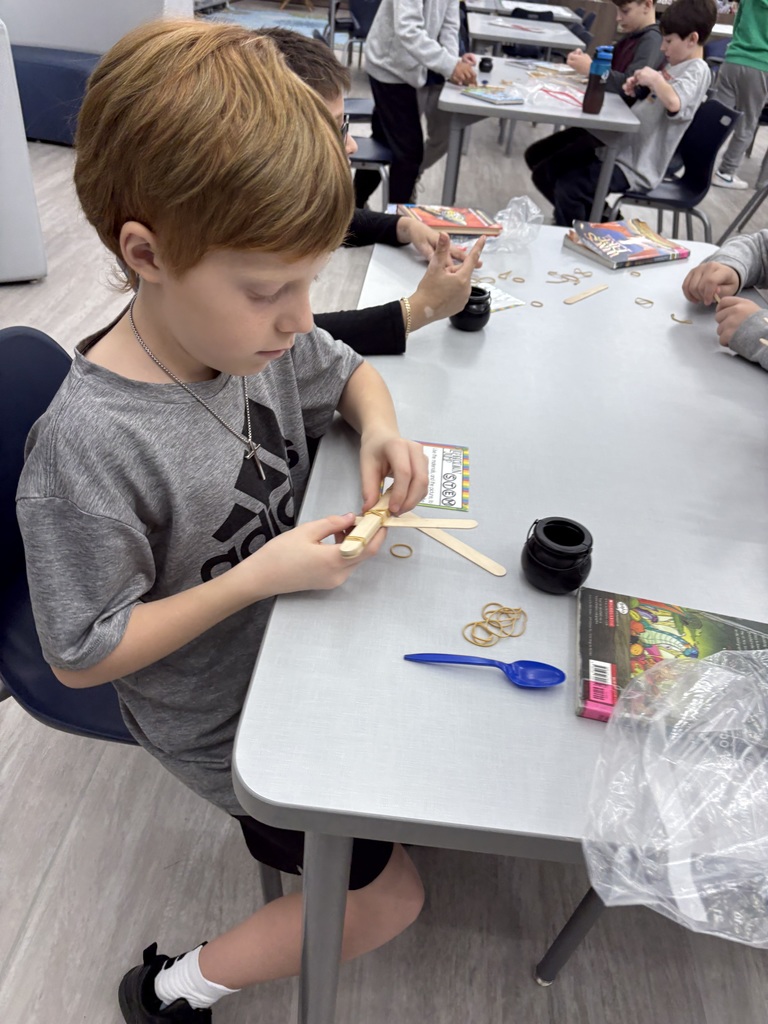 Students building a catapult  in the media center. 