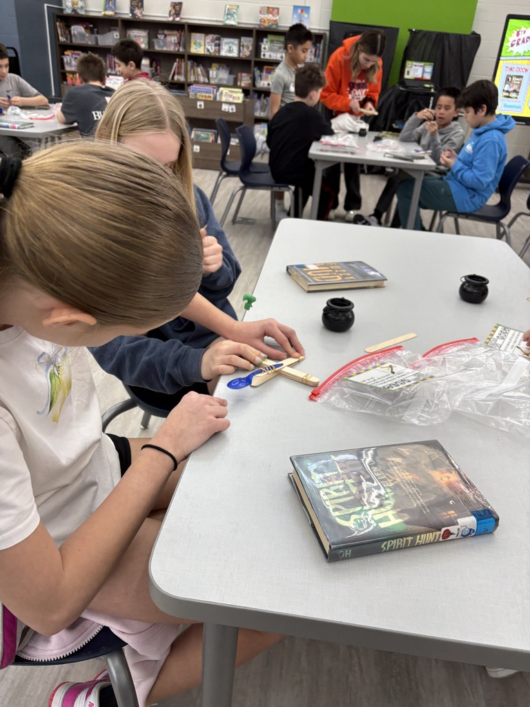 Students building a catapult  in the media center. 