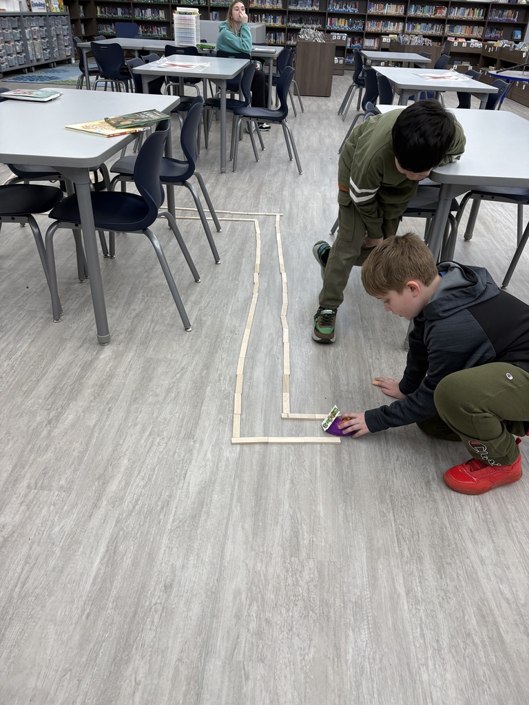 Students building a maze for a coding robot  in the media center. 
