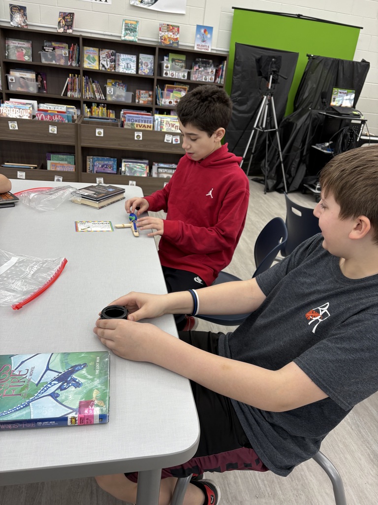 Students building a catapult  in the media center. 