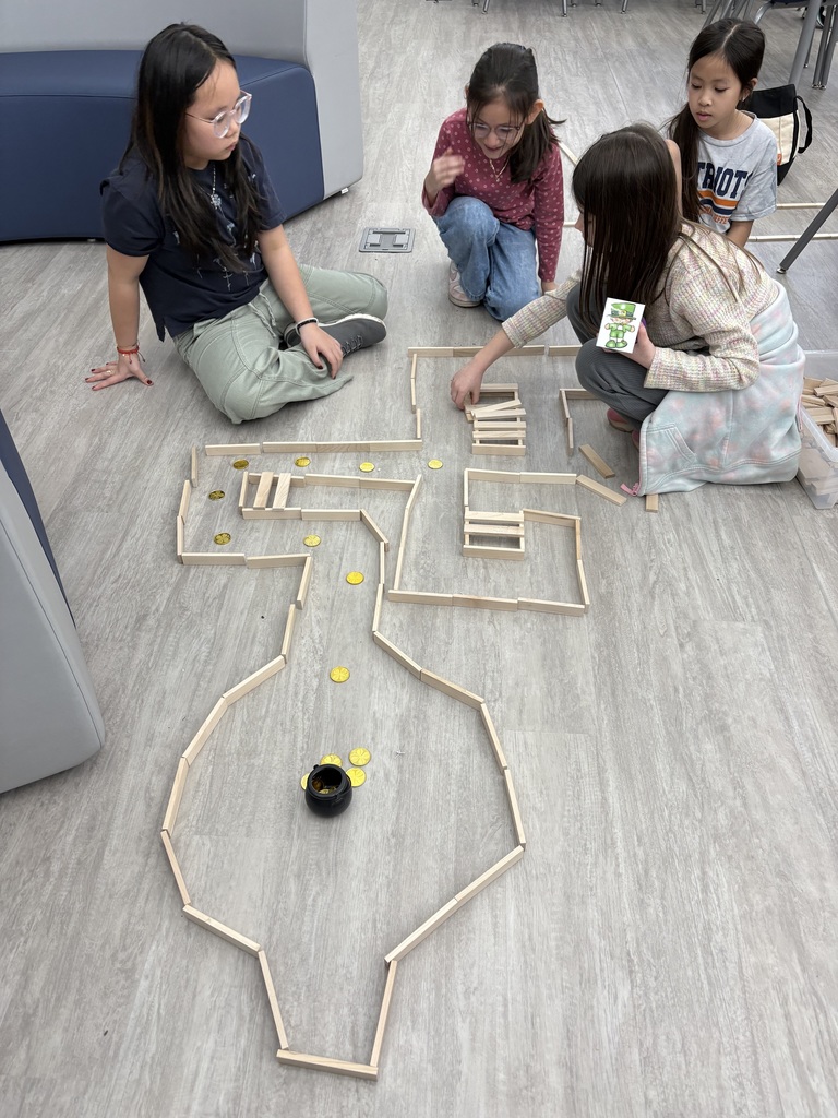 Students building a maze for a coding robot  in the media center. 