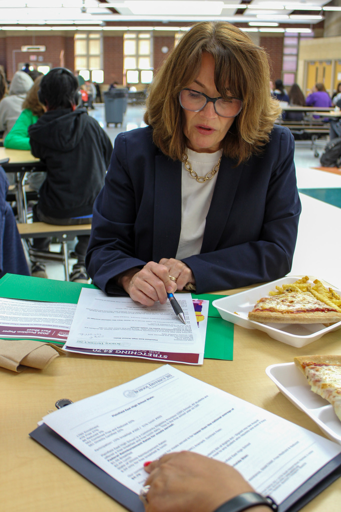 State senator Meg Cappel sits at lunch table and points with pen to paper