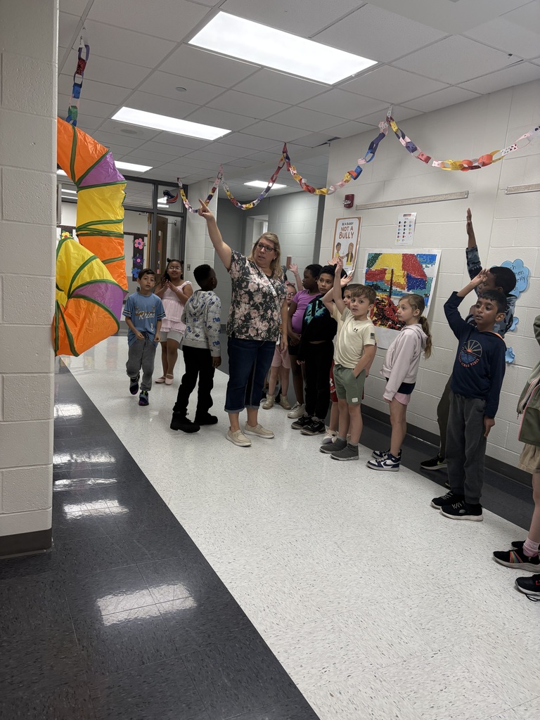 A teacher in the hallway talking to students. 