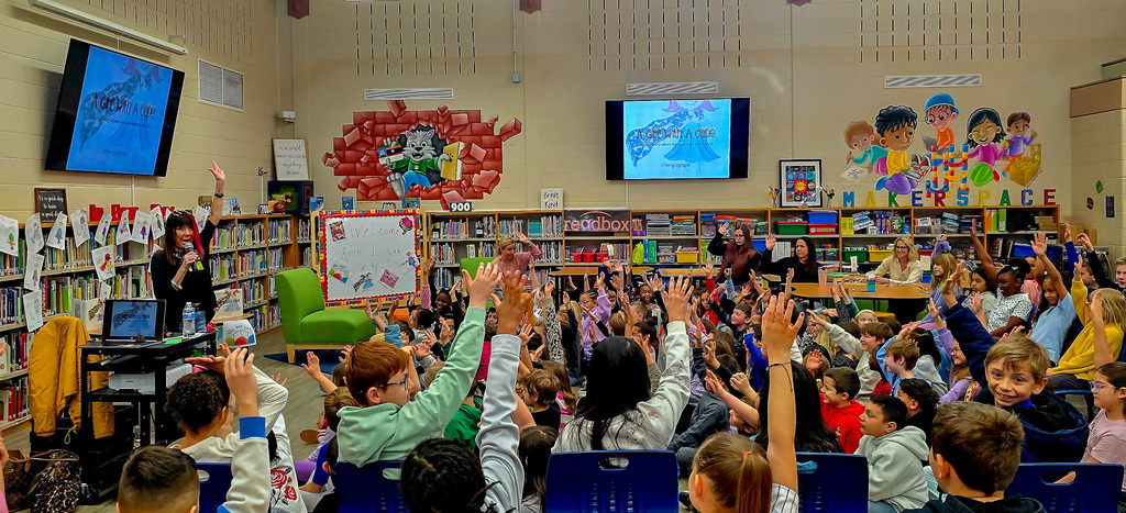 Group of students with hands raised 