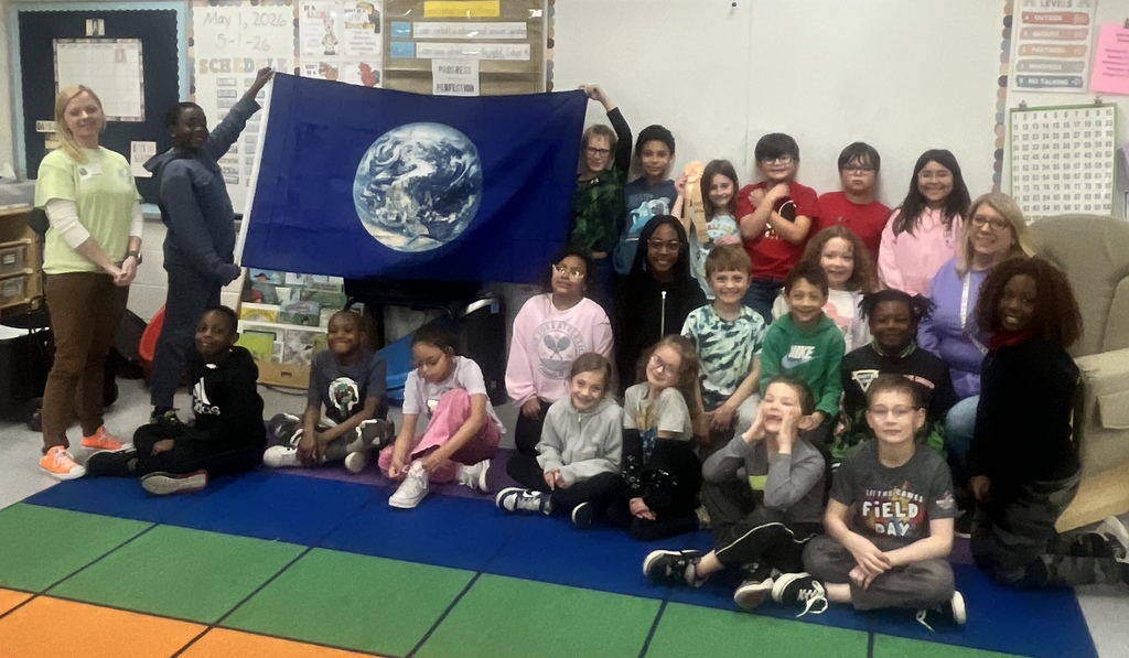 Students in a classroom with a flag of the earth.