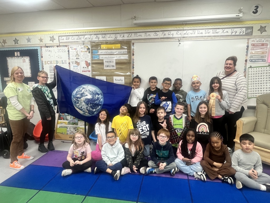 Students in a classroom with a flag of the earth.