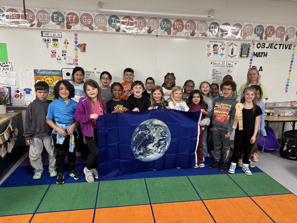 Students in a classroom with a flag of the earth.