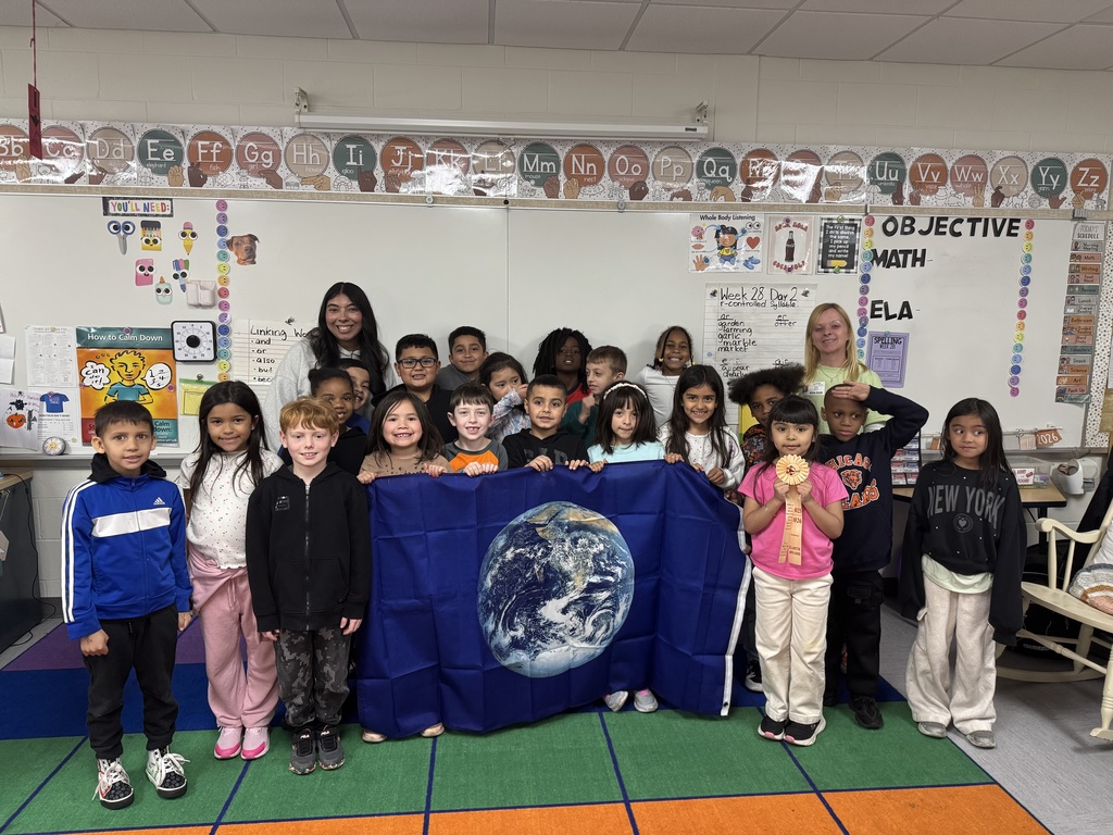 Students in a classroom with a flag of the earth.