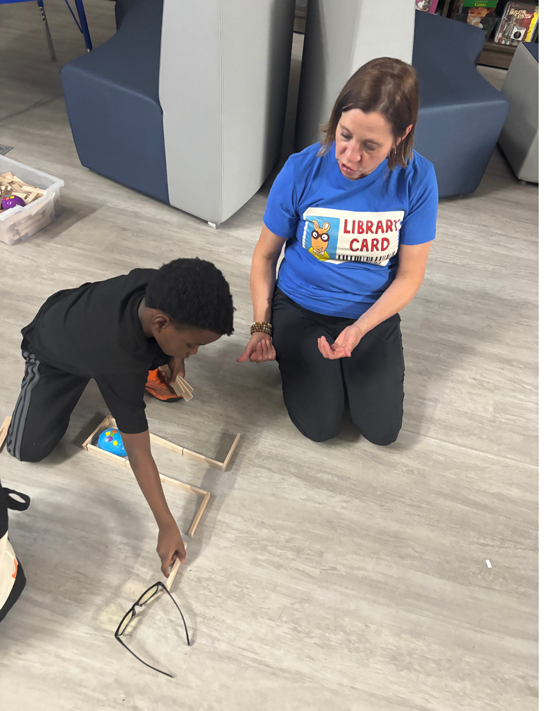 A student coding a robot mouse with a teacher.