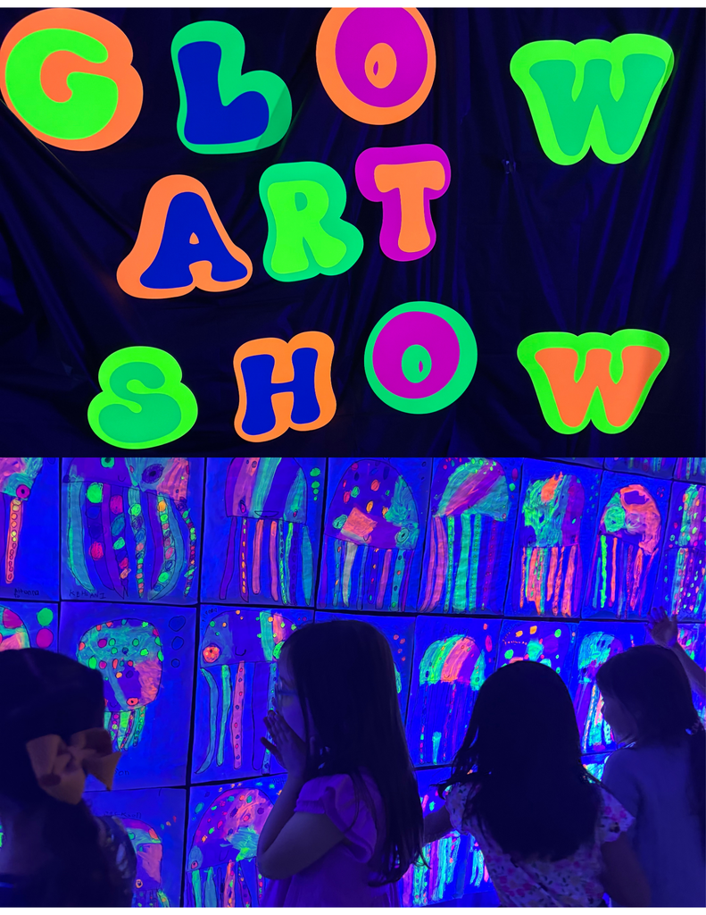 Two students standing in front of glow in the dark art.