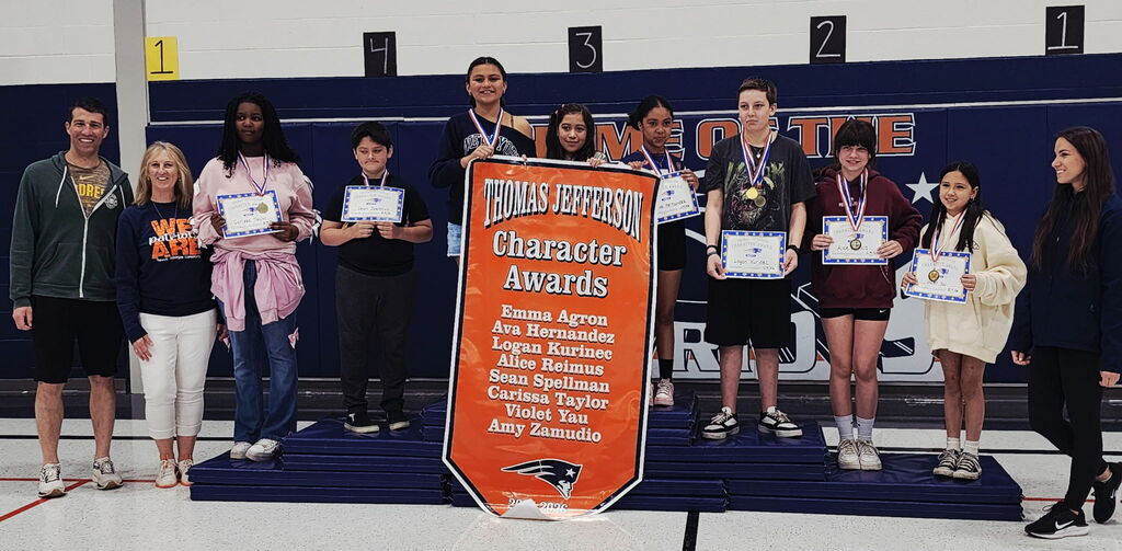 Eight students holding certificates standing in front of a banner