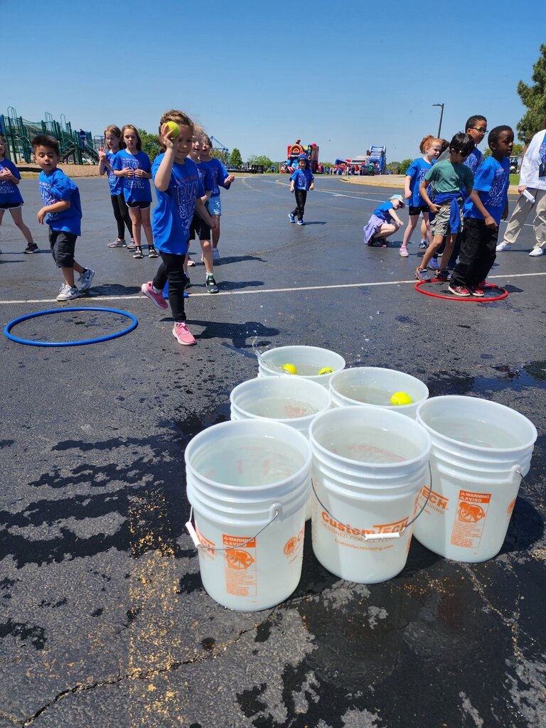 A student throwing balls into buckets. 