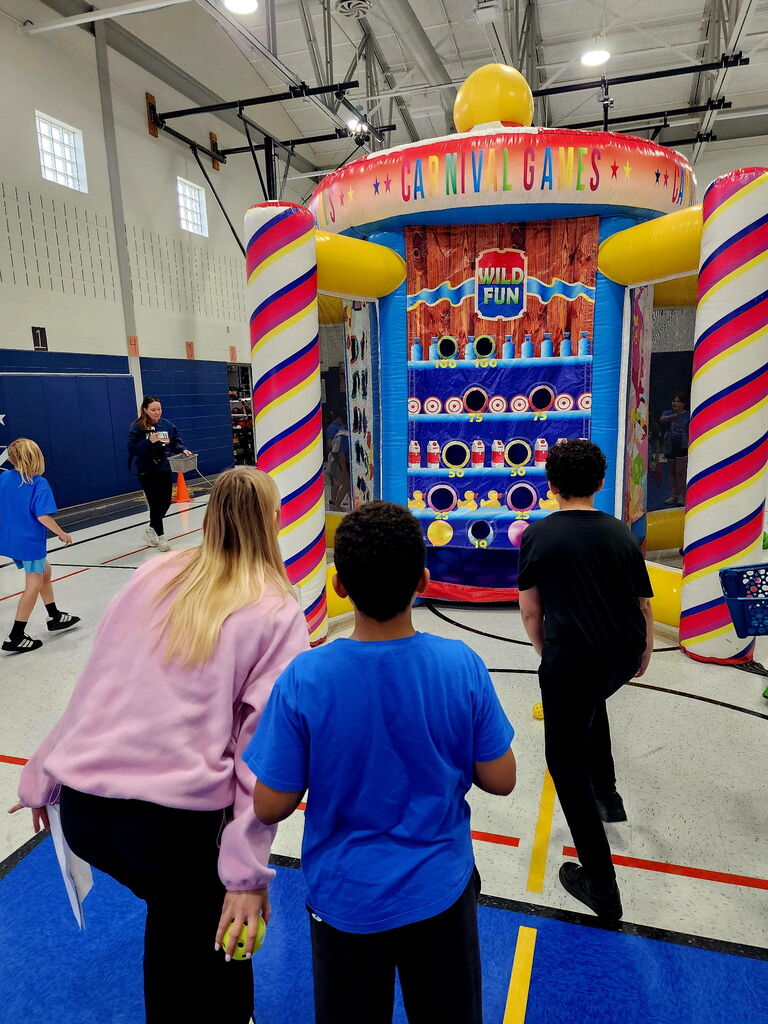 Students in a gym playing a carnival game. 