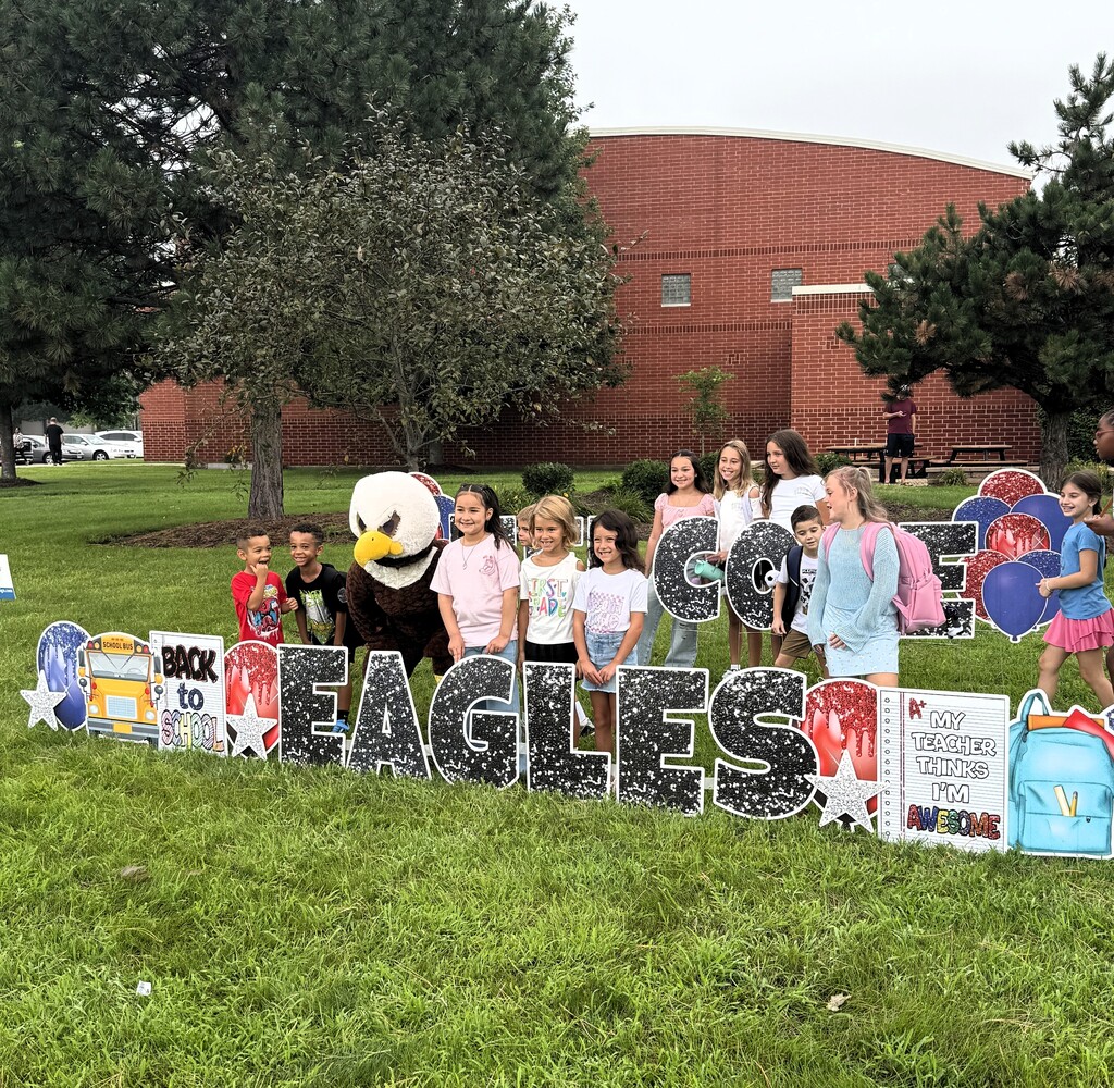 kids outside by welcome back sign