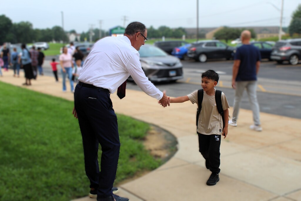 Dr. Wood shakes hands with a student
