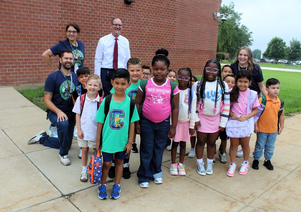 Dr. Wood, Principal Haymond, staff and students stand outside