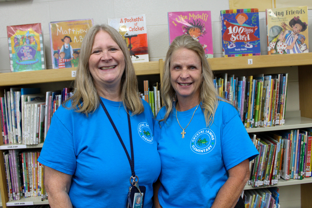 media center specialists stand in front of bookcase