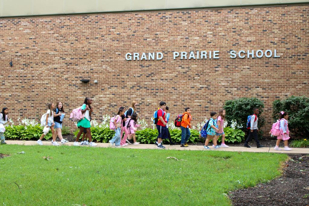 students walk past front of Grand Prairie Elementary School