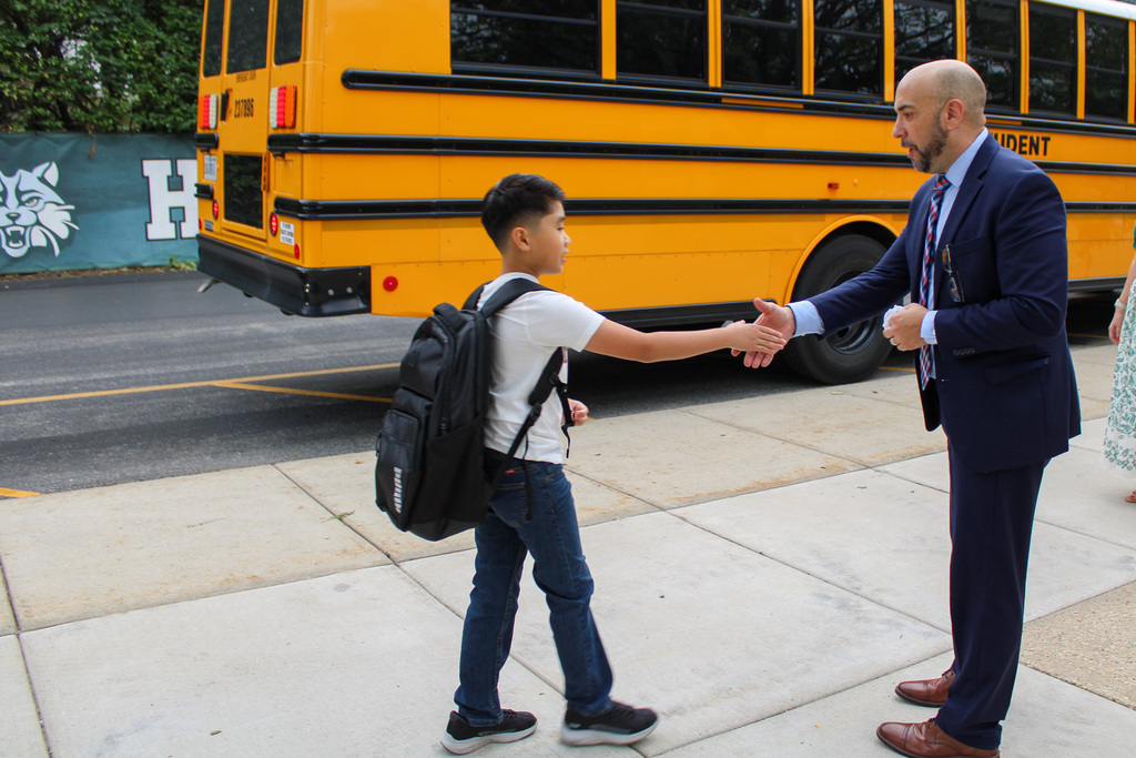 student shakes hand with principal
