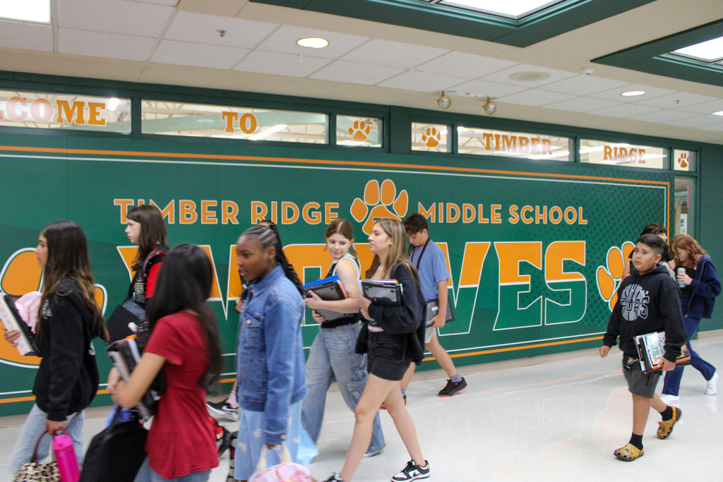 students walk past wall Timber Ridge Middle  School Go Wolves