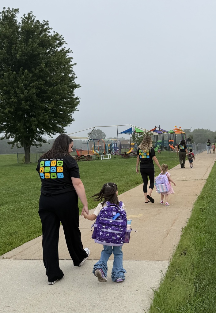 students and teachers walking on sidewalk near playground