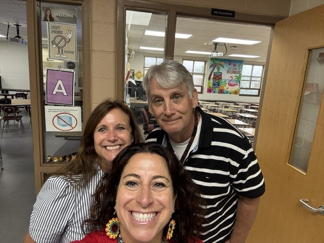 teachers  smiling outside classroom door
