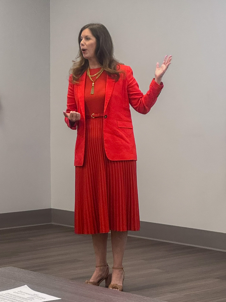 woman in red dress gestures while she speaks