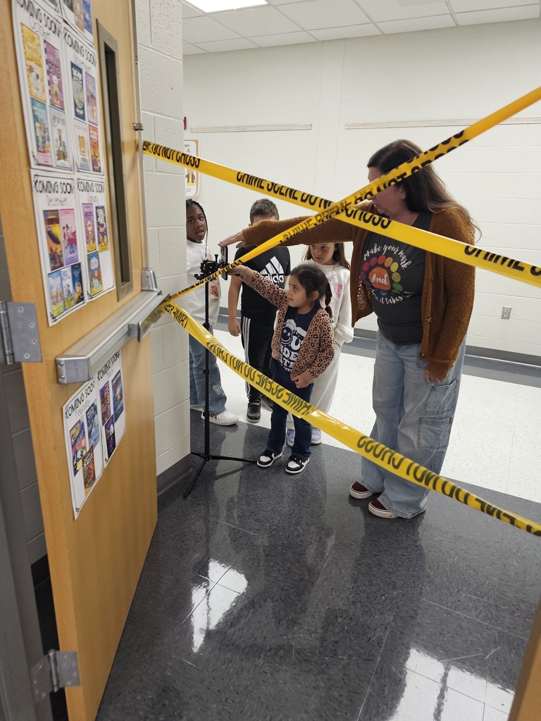 Students using a pretend finger scan outside of a library.