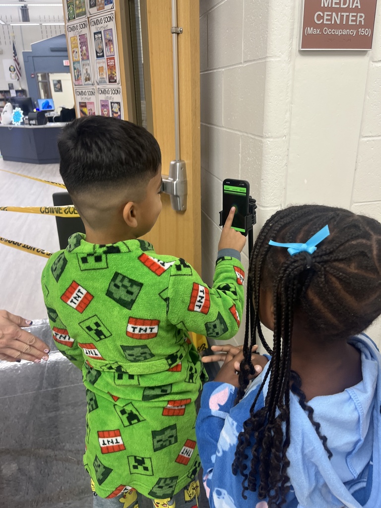 Students using a pretend finger scan outside of a library.