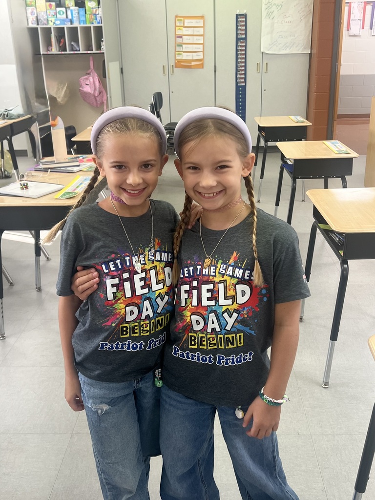 Two students smiling in a classroom.