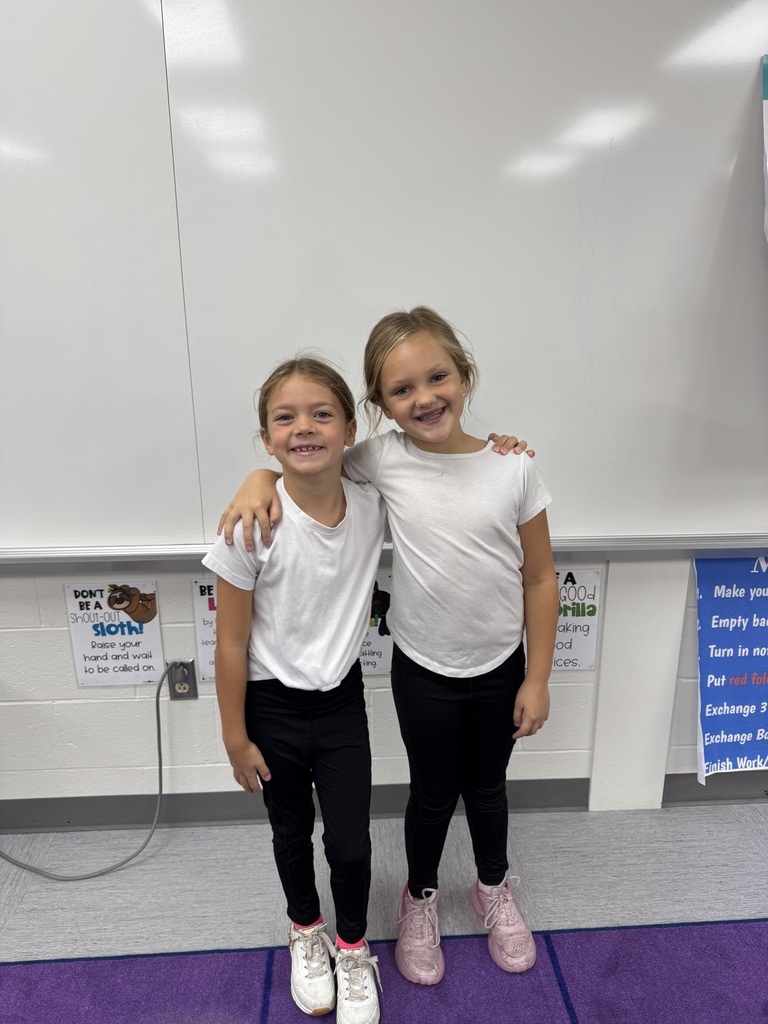 Two students  smiling in a classroom.