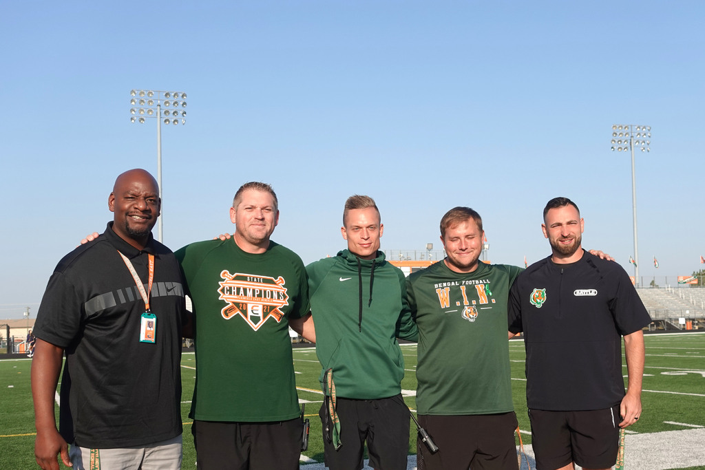 administration taking a picture on the field during the walk