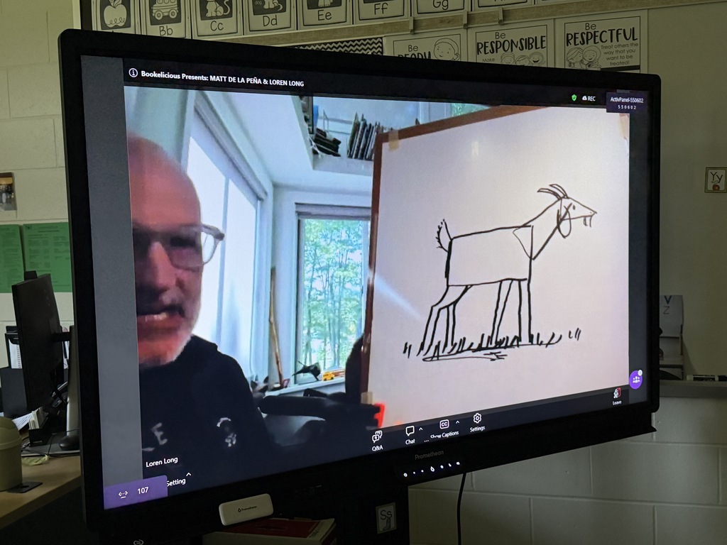 A student shows a goat, drawing on a dry erase board.