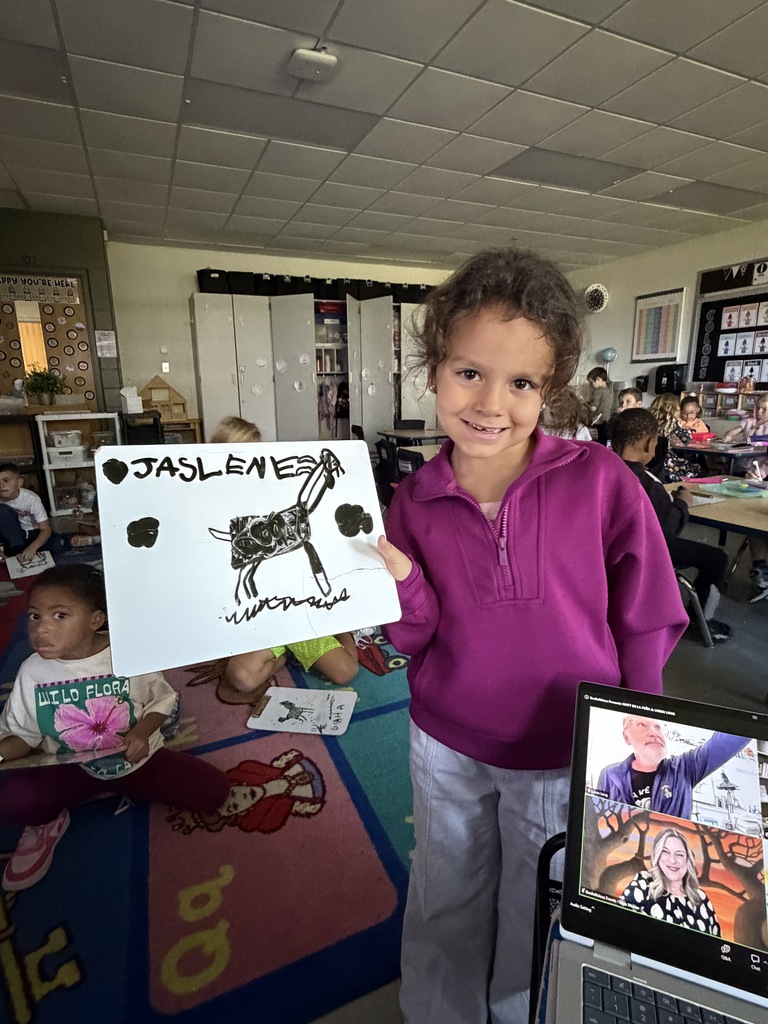 A student shows a goat, drawing on a dry erase board.