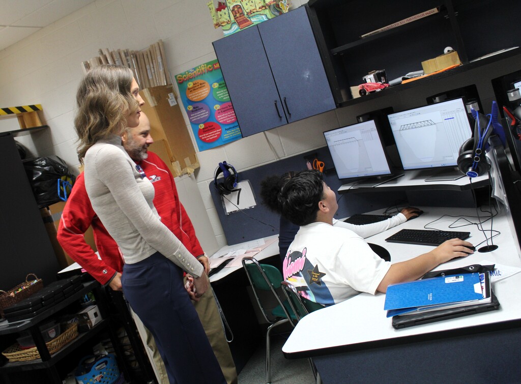 IL State Rep Jessica Dixon Heitman and principal Novinski watch students work on computer
