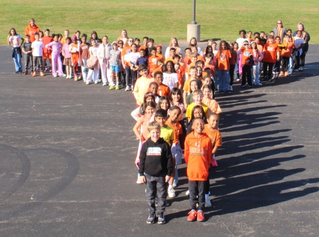 students and staff take pictures outside in orange shirts to show support for Unity Day